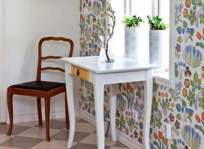 I hallen har familjen lagt in ett schackrutigt linoleumgolv i grått och vitt. På väggen sitter tapeten Vårklockor av Josef Frank.
