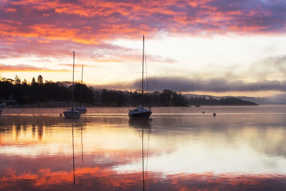 Rosa himmel ovan bukt med båtar.