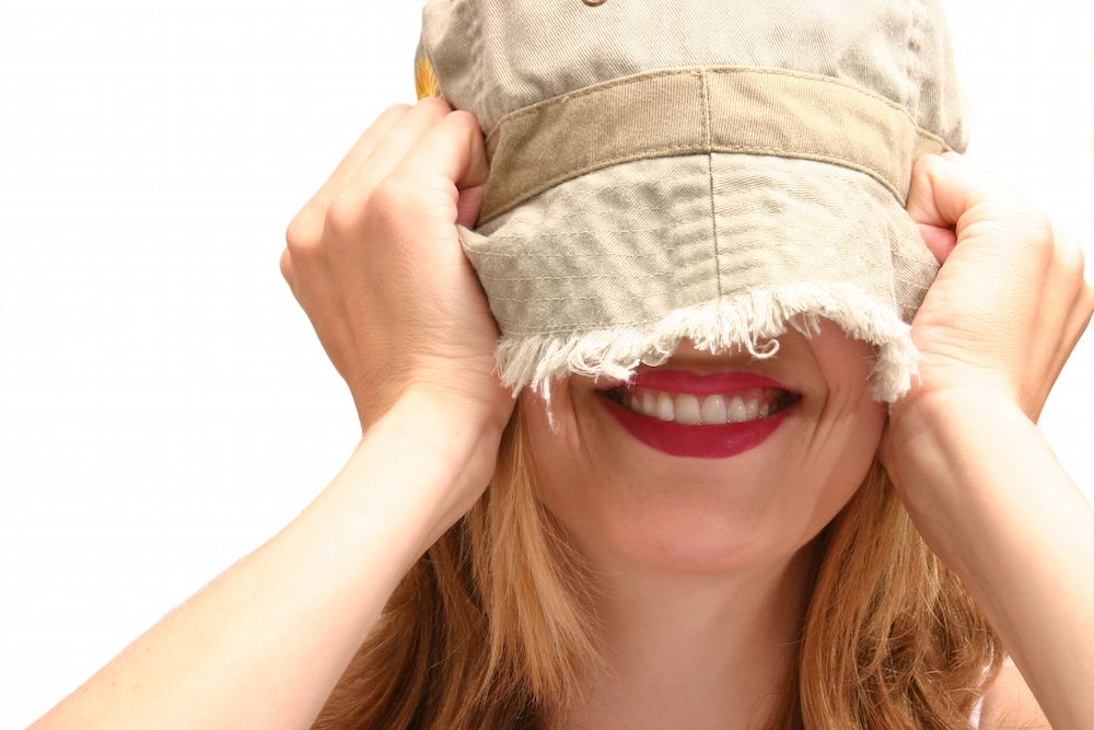 A woman pulling a hat over her head.