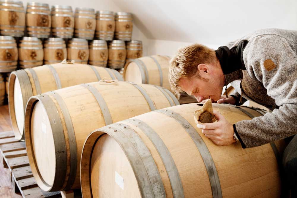 Bonny sniffar över hålet till en av lagringstunnorna för alkoholhaltiga drycker som calvados och sherry.