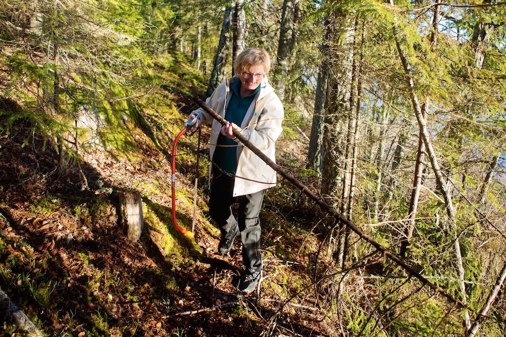 Cecilia ute i gårdens fina skog, som uppskattas av gästerna.