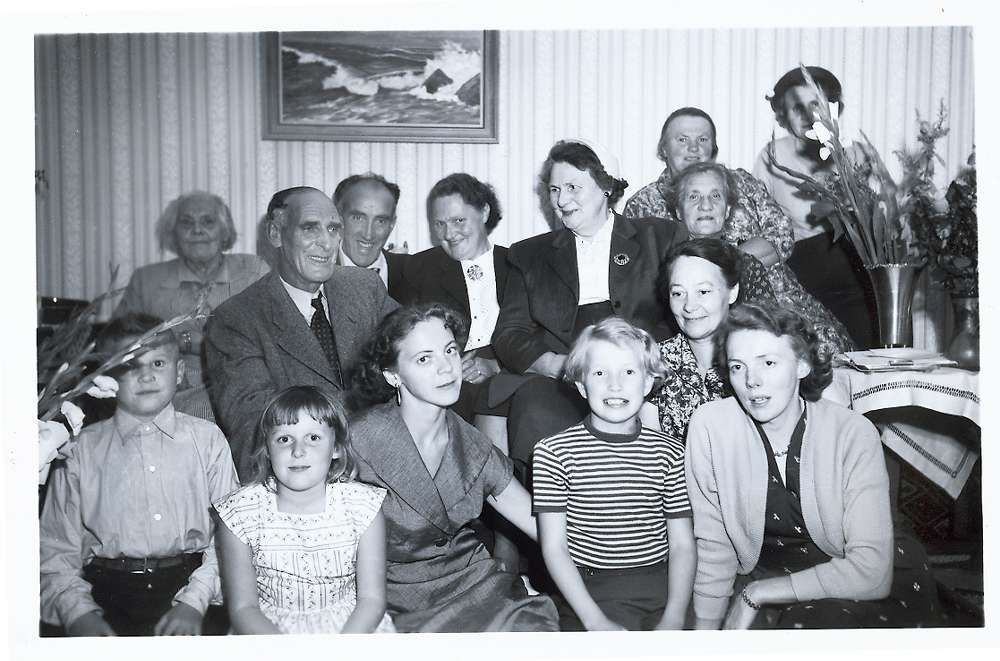 Glada miner. Pappa Gottfrid och mamma Lilly (under tavlan) med släkt och vänner.