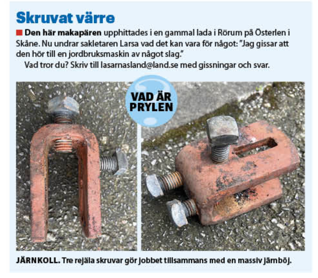 Rostig U-formad metallklämma med tre grova bultar på blå bakgrund
