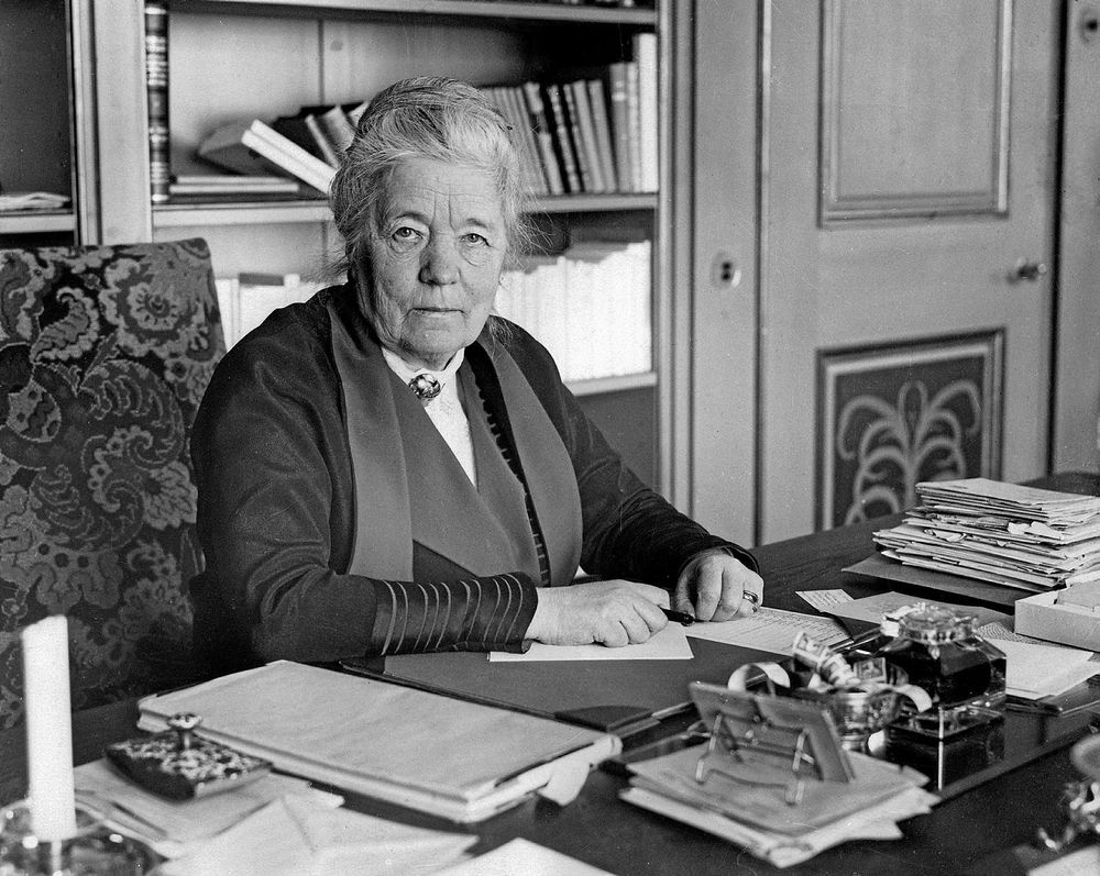 Svartvitt foto på Selma Lagerlöf som sitter vid sitt skrivbord på Mårbacka.