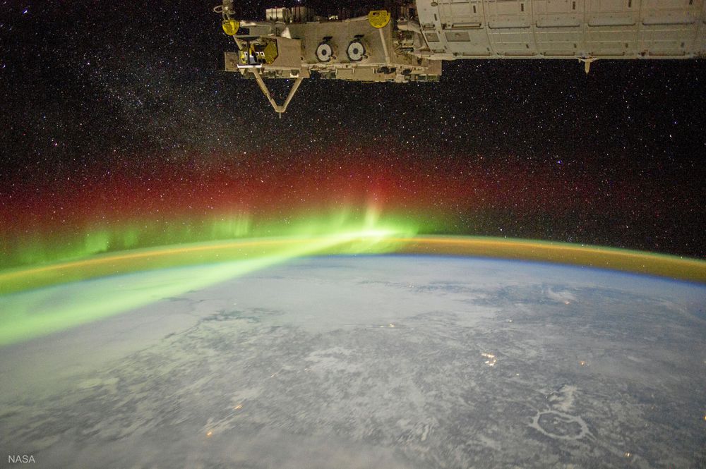 Från boken: Polarsken (på norra jordklotet även kallat norrsken) sett från rymdstationen ISS över Kanada. På bilden ses också ”luftsken”, ett svagt grönblått sken fördelat över atmosfären.