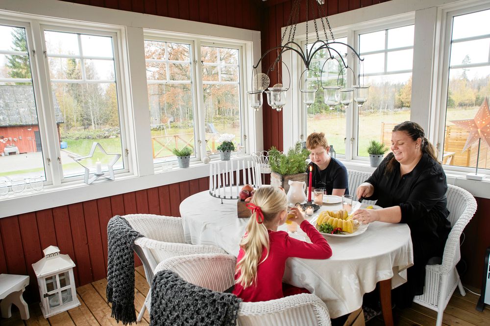 Bodil skär upp bitar av den nybakade saffranskakan till barnen Ludvig och Linnea.