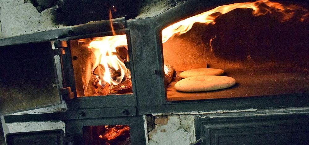 De öppna lågorna i vedugnen gör att brödkakorna blir klara på bara några minuter.