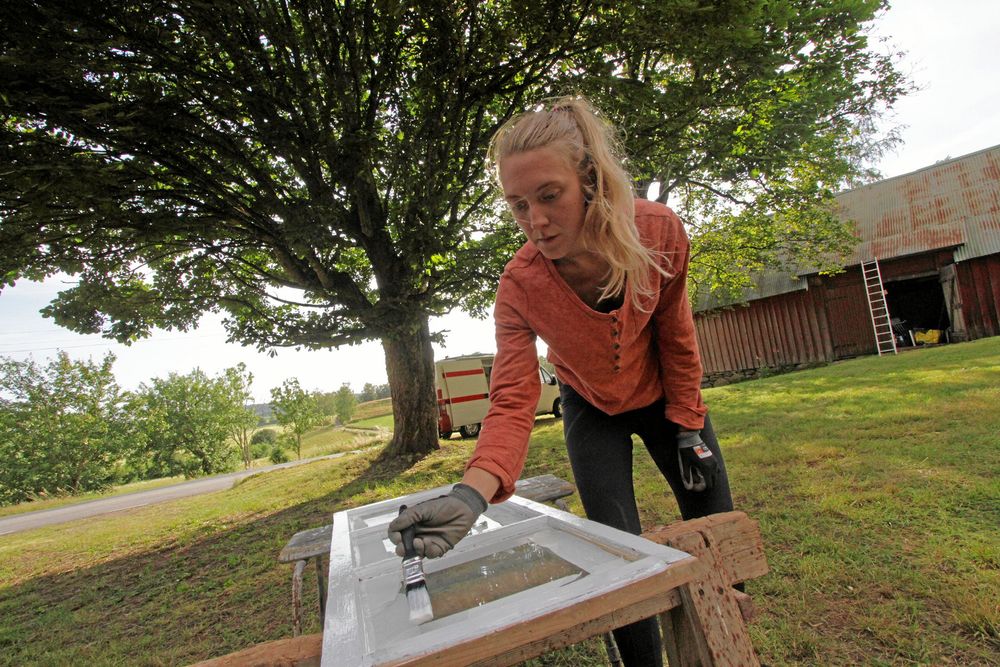 Emilia målar fönster. De flesta har gammalt, munblåst glas.