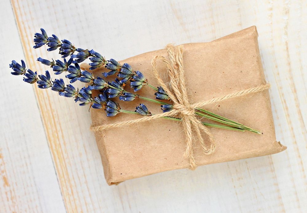 Paket inslaget i brunt papper med blå blommor och hampasnöre.