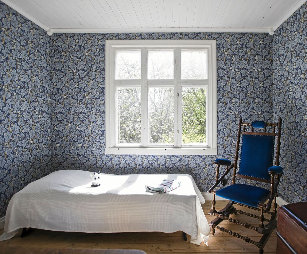 Blåblommigt. Den vackert blåmönstrade tapeten dominerar det kombinerade arbets- och gästrummet.