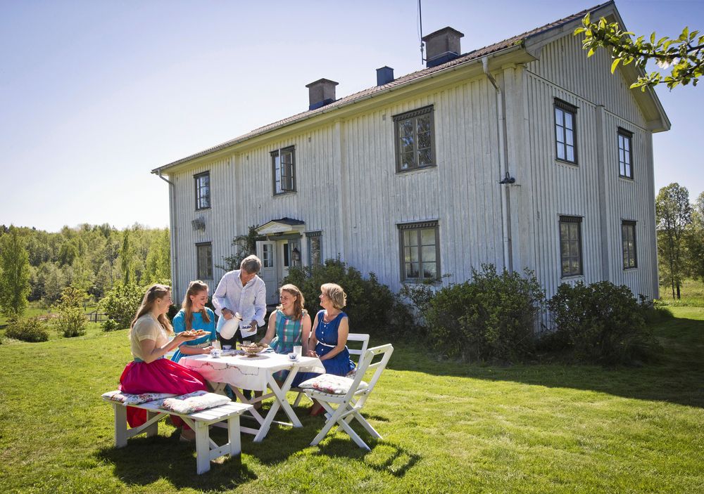 Pappa Lars-Inge serverar kaffe till sina döttrar och fru Ulrika utanför huset som byggdes i samma stil som