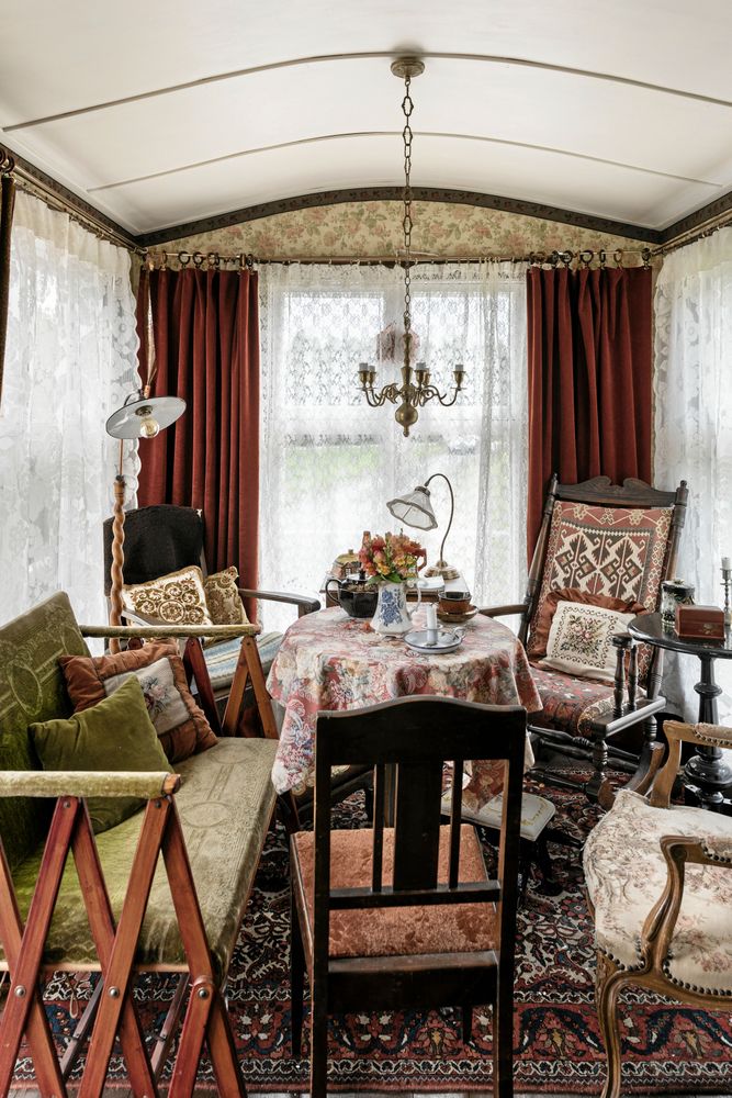 Sammets- och spetsgardiner och blommönster ger känslan av ett gammaldags irländskt vardagsrum inne i bostadsvagnen.