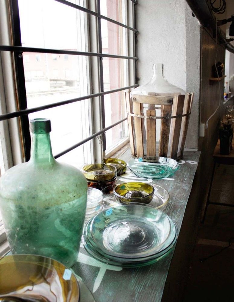 I fönstret står olika skapelser av återbrukade glasflaskor och kärl.