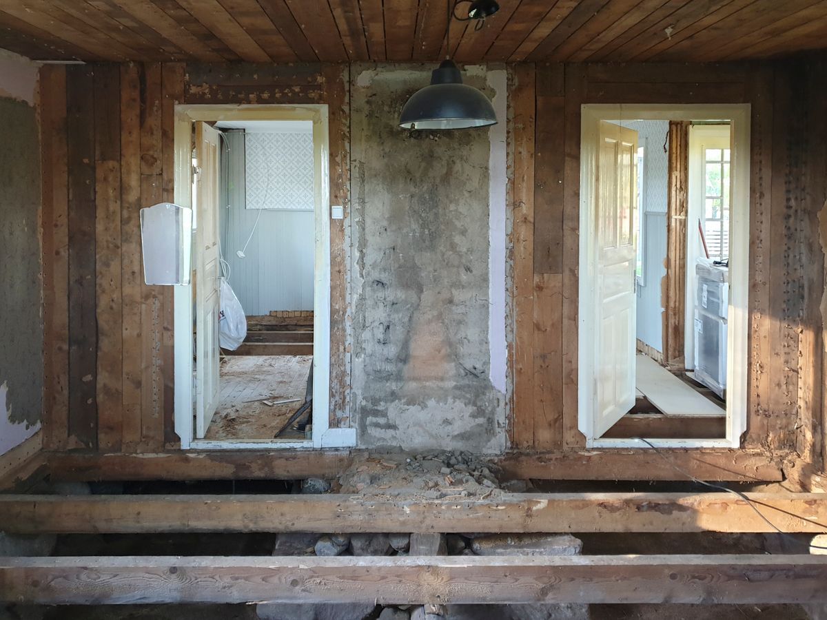 Gammalt hus under renovering med öppna väggar, synliga reglar och utan golv