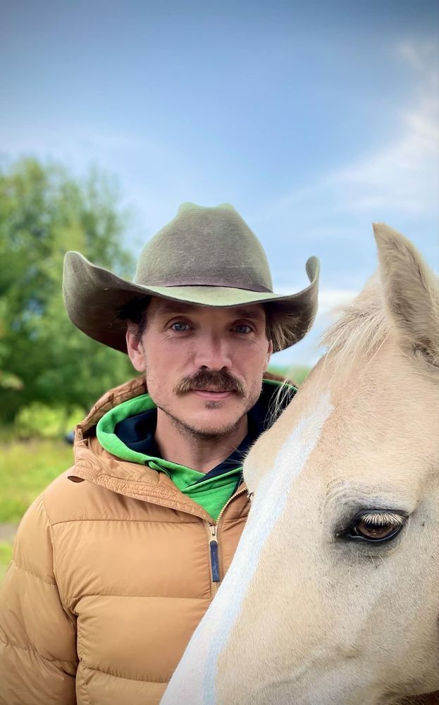 Oskar Öhrström i hatt och hästen Ivory utomhus.