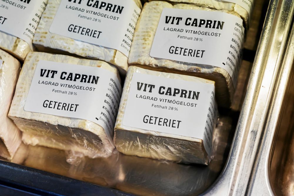 Vit Caprin-ostar med vitmögel i förpackningar.