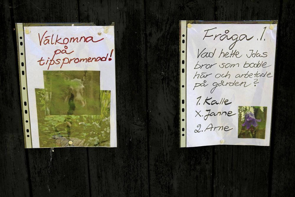 Två skyltar som välkomnar till en tipspromenad med frågor.