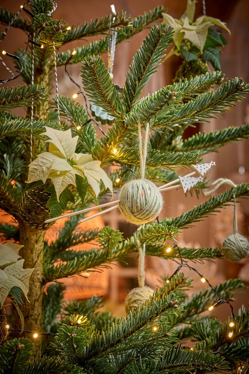 Julgran med kulor och ljusslingor dekorerad.