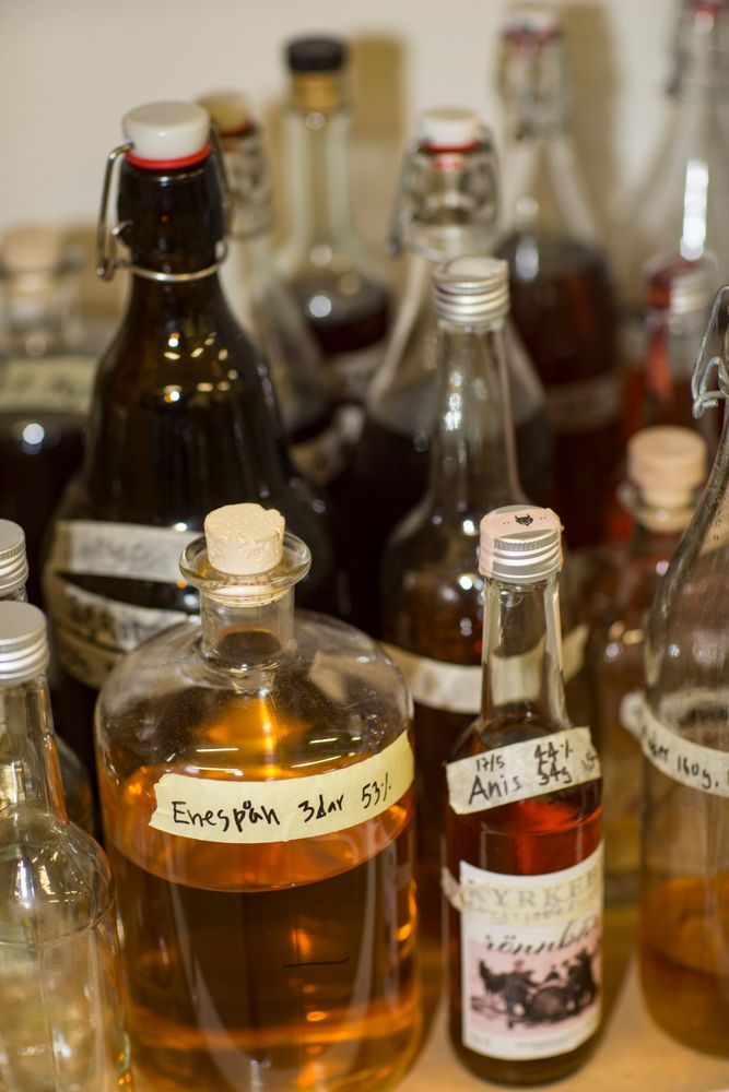 Brännvinsflaskor med olika etiketter som visar vilka kryddor som använts.
