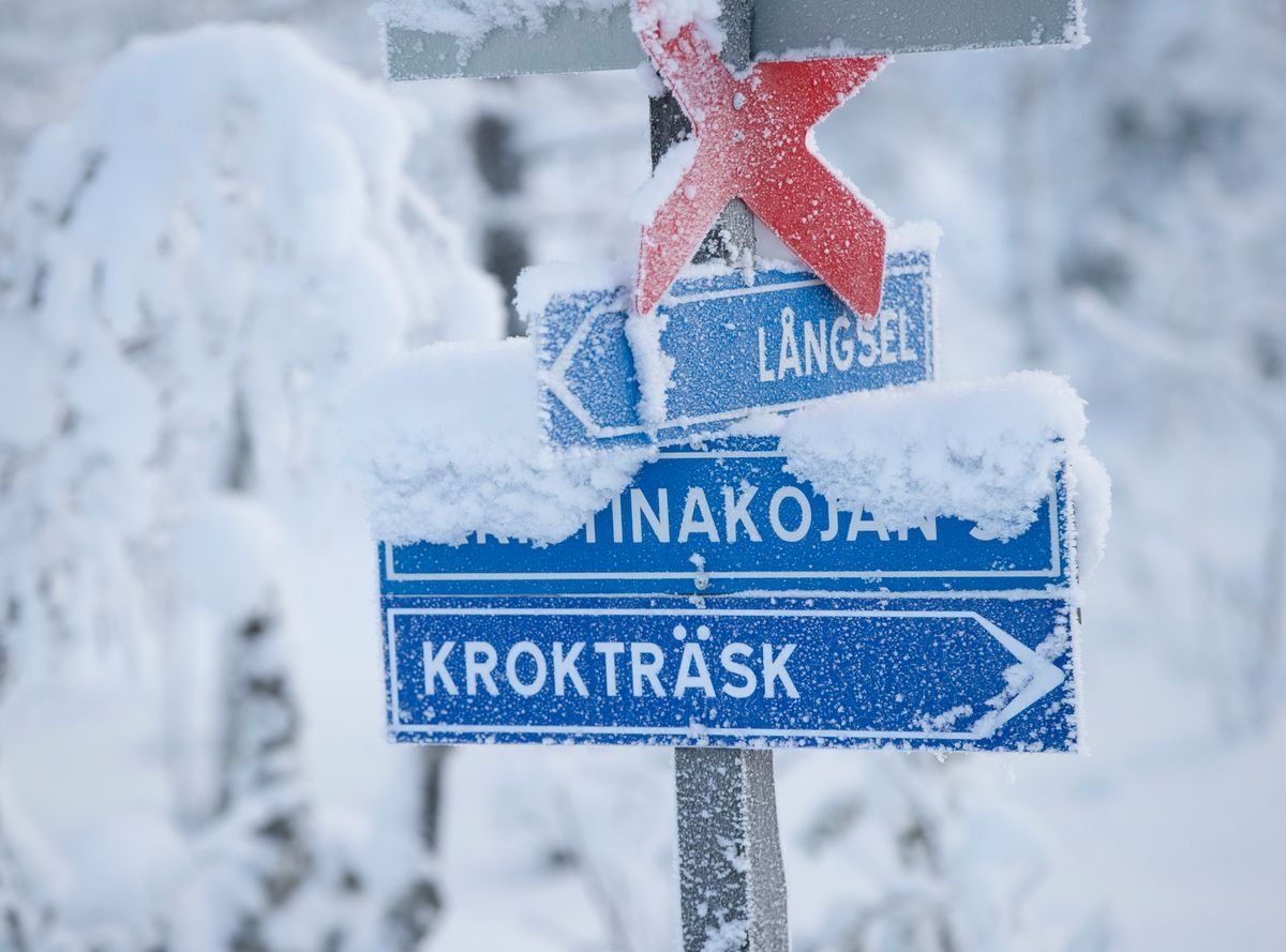 Vägskyltar täckta av snö pekar mot Krokträsk och Kristinakojan