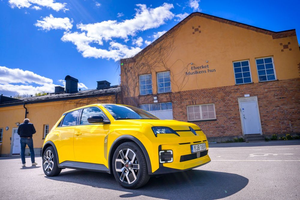 Gul Renault R 5 E-tech parkerad framför äldre industribyggnad.