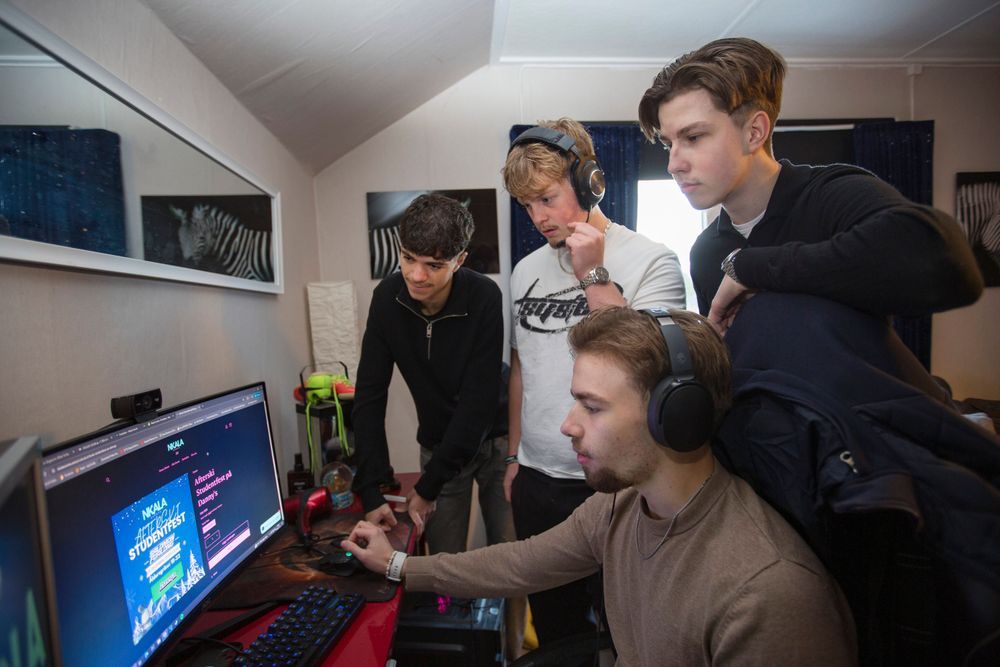 Khaled, Marwin, Simon och Ebbe står och sitter framför datorskärm.