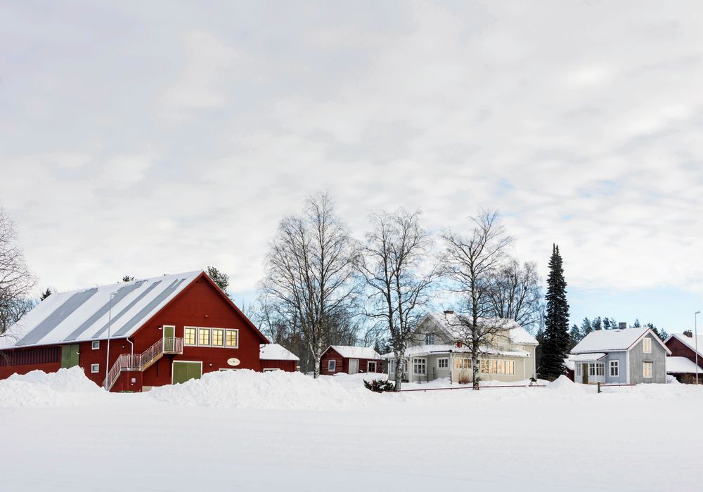 Gården med ett av gästhusen i bakgrunden och fårladan i förgrunden där trappan leder upp till gästrummen.