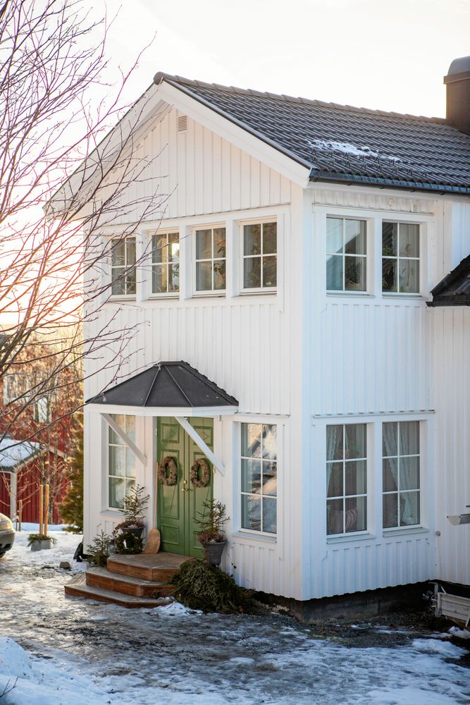 Huset är från 1950 och fräscht vitmålat med gröna dubbeldörrar.