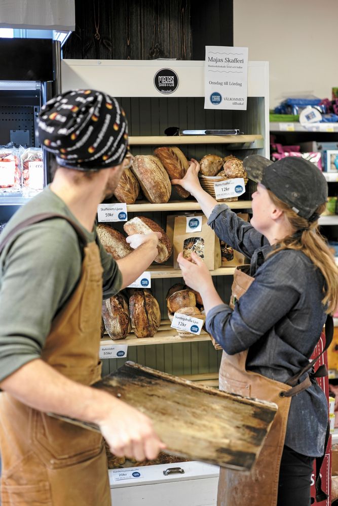 Paret fyller på nybakt bröd i bageriets eget skåp i Ica-butiken.