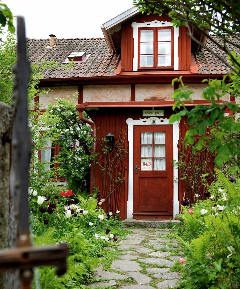 Det gamla boningshuset är varsamt renoverat med tidstypisk färg, material och inredning. Och omgärdas av en gammeldags och frodig trädgård. Foto: Carolina Romare