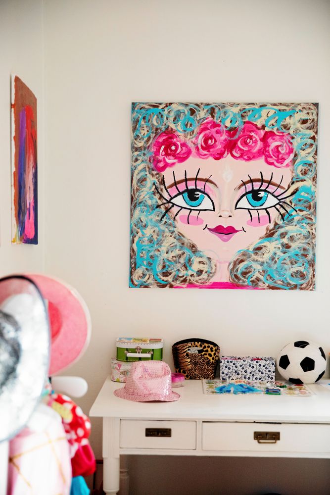 På väggarna sitter Toves färgglada målningar.