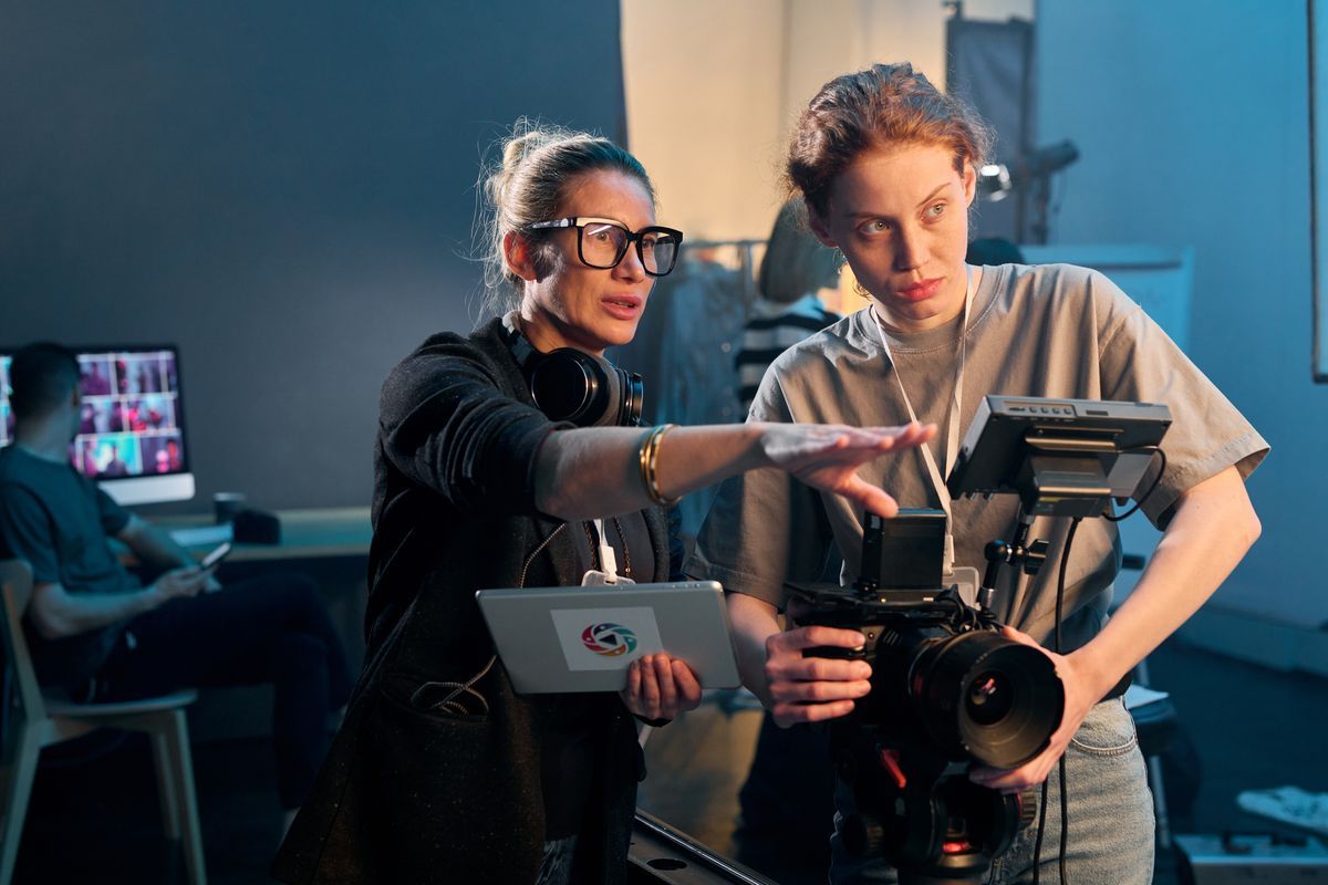 Waist up portrait of female director giving instructions working in video production and operating cameras copy space