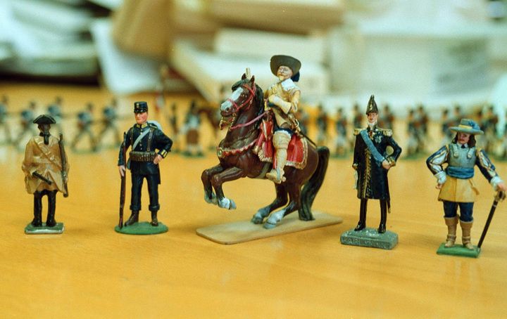 Målade tennsoldater på ett bord, med en ryttare på häst i centrum
