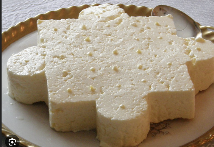 Vit dessert i form av pusselbit på fat med sked bredvid