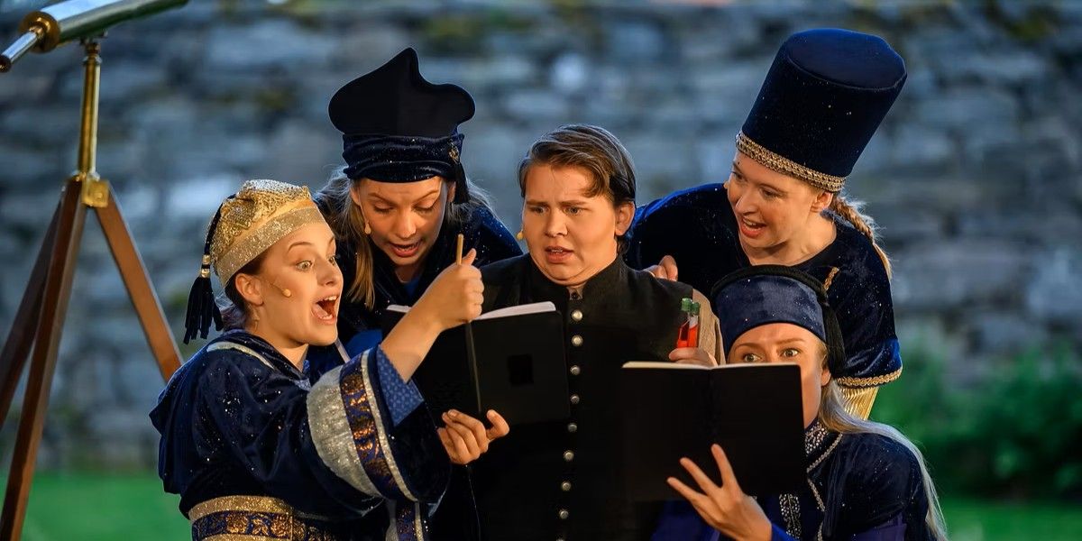 Fem skådespelare i färgglada kostymer samlas och läser ur böcker utomhus